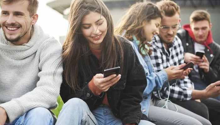 Gmfu and digital literacy - tycoonstory | tycoonstory media Gmfu meaning explained through a digital literacy concept showing people using smartphones and understanding internet slang, social media abbreviations, and modern online communication trends