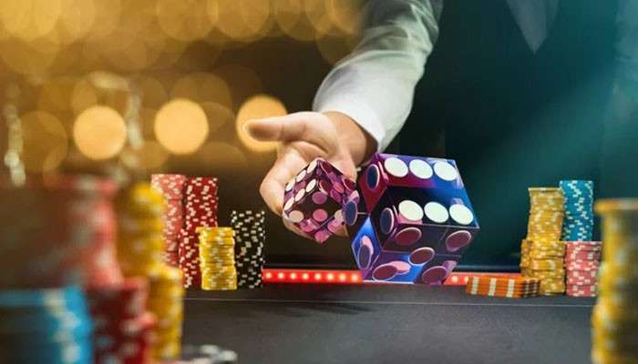 A rulebook can cap the turnover lever | tycoonstory media A hand rolling purple dice across a casino table with colorful poker chips in the background.