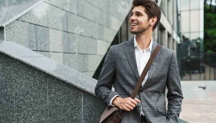 How to choose the right messenger bag for men - tycoonstory | tycoonstory media Messenger bag for men styled with a professional business outfit, featuring a sleek crossbody design, adjustable shoulder strap, premium appearance, and practical everyday carry solution for office, commuting, and urban lifestyle needs.
