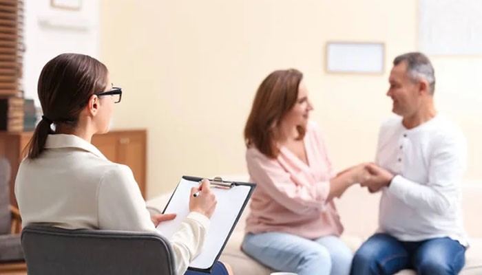 The 6 best addiction treatment centers in new jersey | tycoonstory media Counselor in a light blazer takes notes on a clipboard while a couple shakes hands in a therapy session.