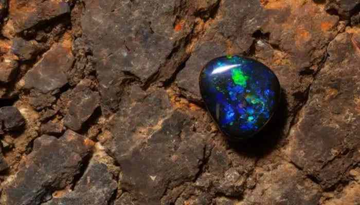 Lightning ridge black opal - tycoonstory | tycoonstory media October birthstone black opal from lightning ridge australia featuring vibrant blue and green play-of-color patterns, rare gemstone formation, natural beauty, symbolism, and opal jewelry significance