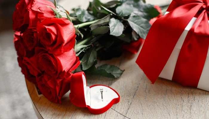 Unique anniversary gifts for her - tycoonstory | tycoonstory media 14 year anniversary gift ideas featuring a romantic red rose bouquet, heart-shaped jewelry box with a ring, and elegant wrapped presents symbolizing love, commitment, and thoughtful 14th wedding anniversary celebrations.