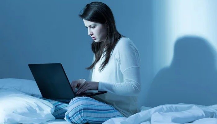 Requests for unnecessary personal information - tycoonstory | tycoonstory media Woman sitting on a bed at night using a laptop to explore a dream interpretation site and understand possible meanings behind her dreams.