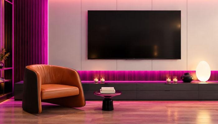 Things to check before buying | tycoonstory media Modern living room with a wall-mounted flat-screen tv, purple ambient lighting, and a tan leather lounge chair beside a small round table with books.