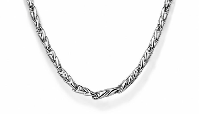 How can you style mens jewelry without looking overdressed? | tycoonstory media Close-up of a silver twisted chain necklace curved in a shallow arc on a white background.
