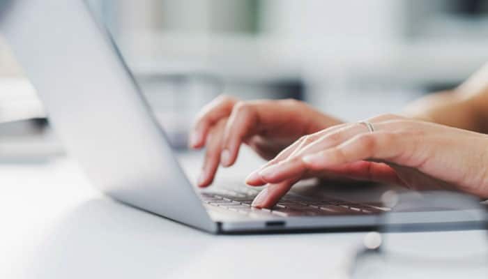Is riproar business news legit - tycoonstory | tycoonstory media Person typing on a laptop while researching riproar business news coverage, reliability, market trends, company updates, finance, and technology.