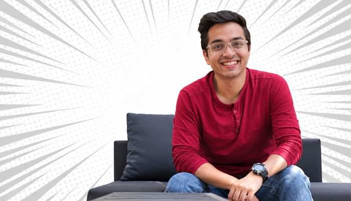 Kartik ahujas experience with business automation - tycoonstory | tycoonstory media Kartik ahuja growth marketing consultant smiling while seated on a sofa, wearing a red shirt and glasses against a white radial background.