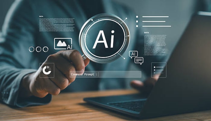 The counterintuitive truth about how ai changes what visibility means 1 | tycoonstory media Close-up of a hand pointing toward a holographic ai interface with a circular 'ai' icon and digital data graphics above a laptop.