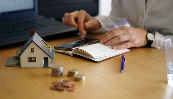 What deposit is required for a vente longue - tycoonstory | tycoonstory media Vente longue in france property deposit calculation with a house model, coins and financial documents, illustrating funds agreed during a french property sale.